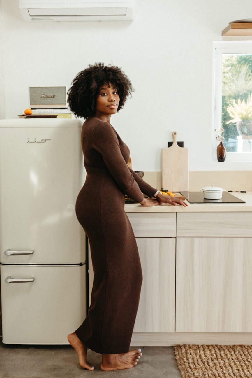 Woman wearing brown dress standing in kitchen