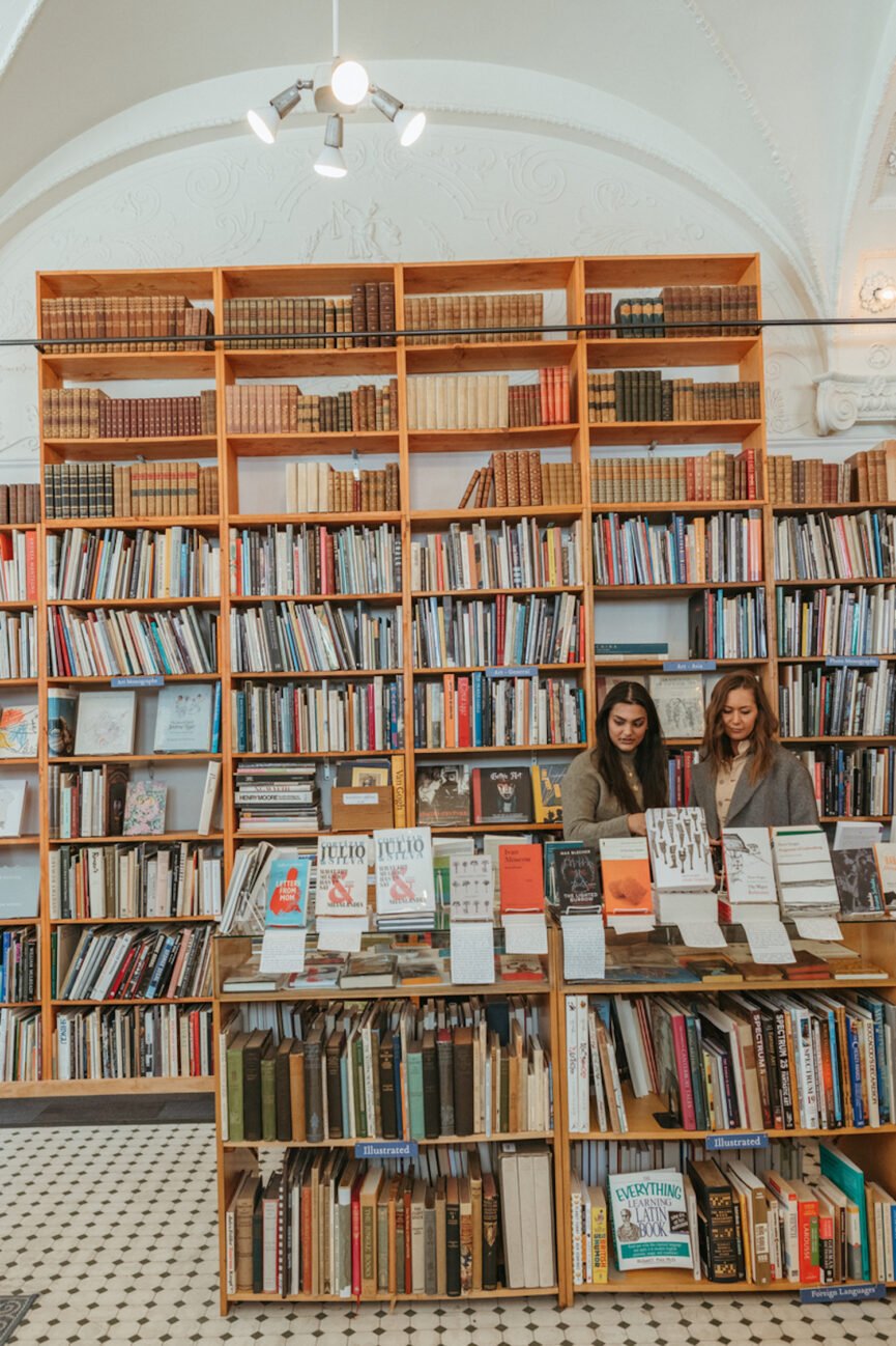 Women romanticizing autumn browsing astatine a bookstore.