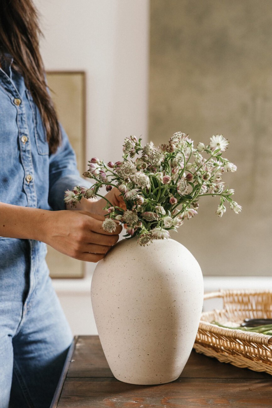 Mulher arrumando flores em vaso