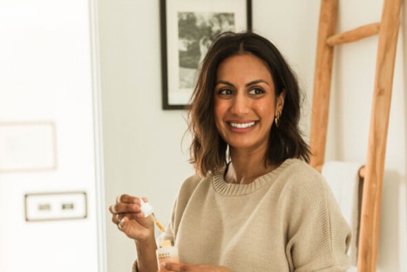 Woman applying facial skin serum.