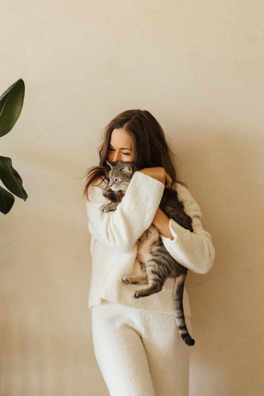 Woman snuggling cat.