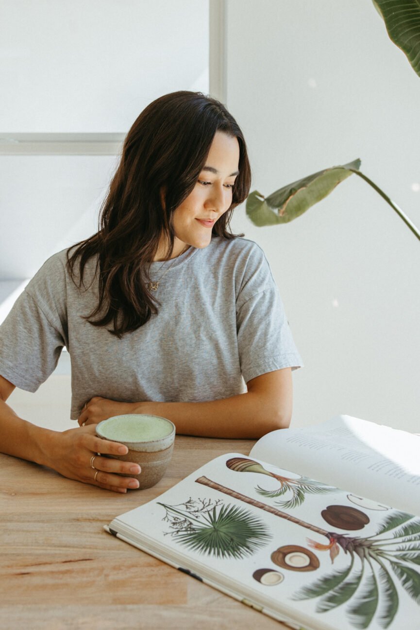 Woman reading book and drinking matcha