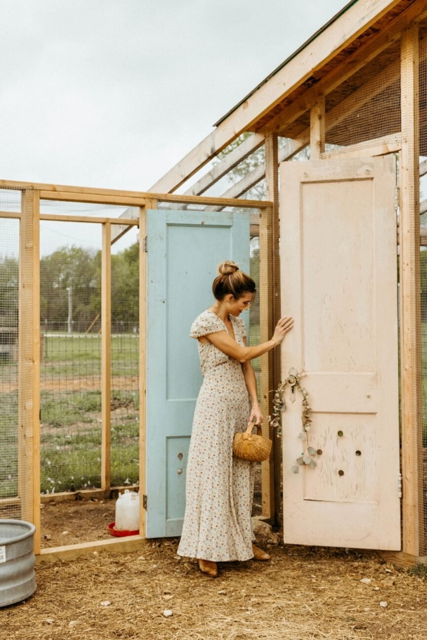 Woman collecting eggs in the chicken coop outside.