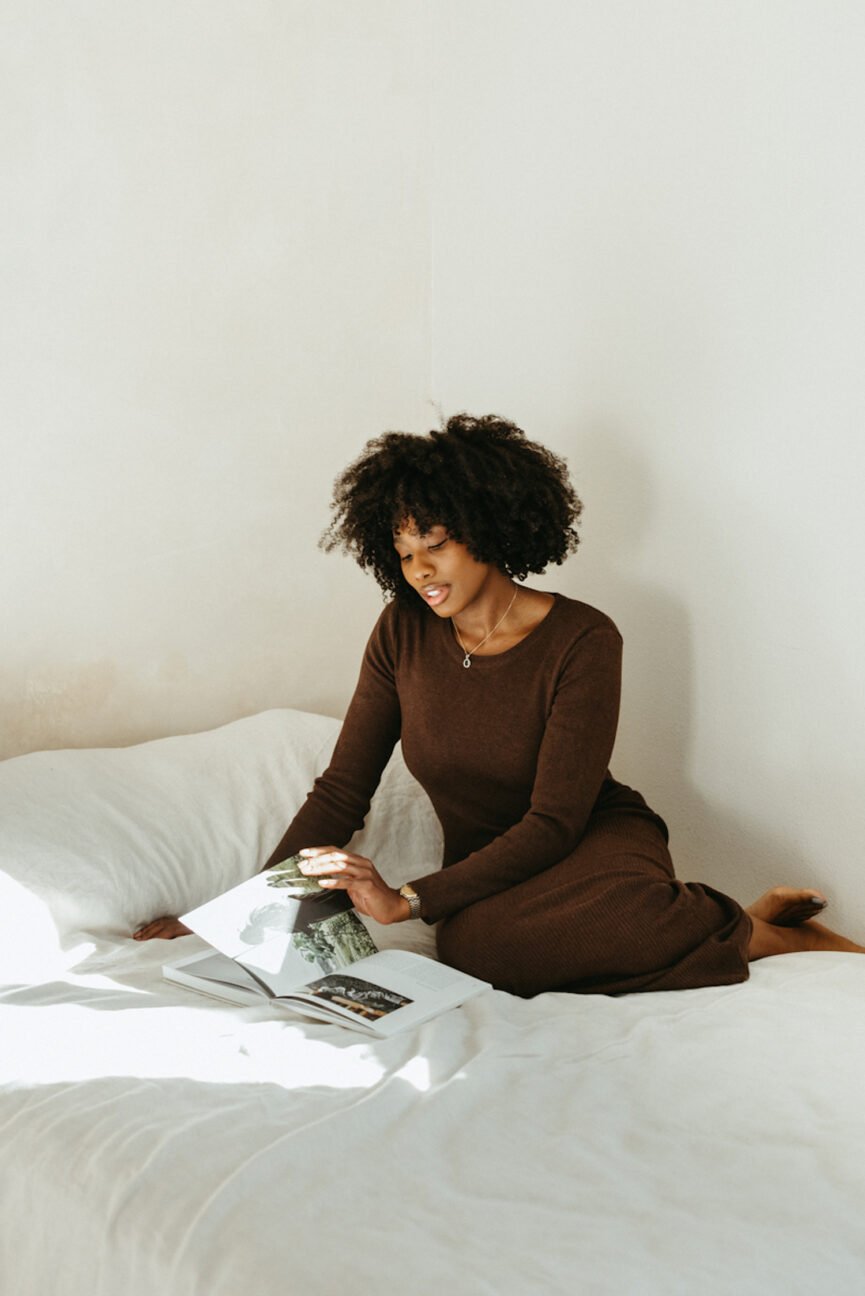 A woman reading a book in bed.