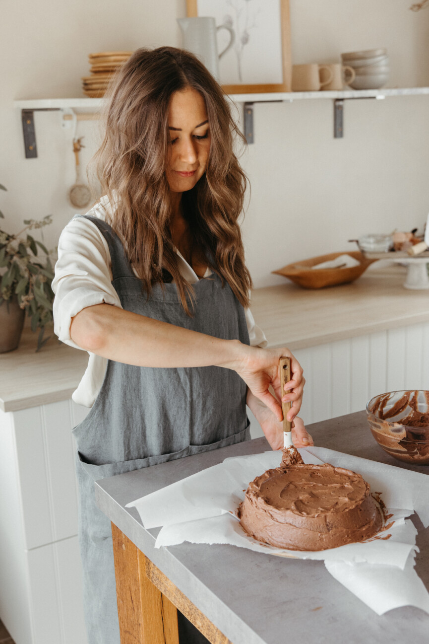 Camille Styles frosting a grain-free chocolate cake_libido-enhancing Valentine's Day menu