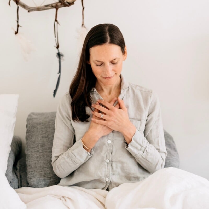 Woman meditating in bed.