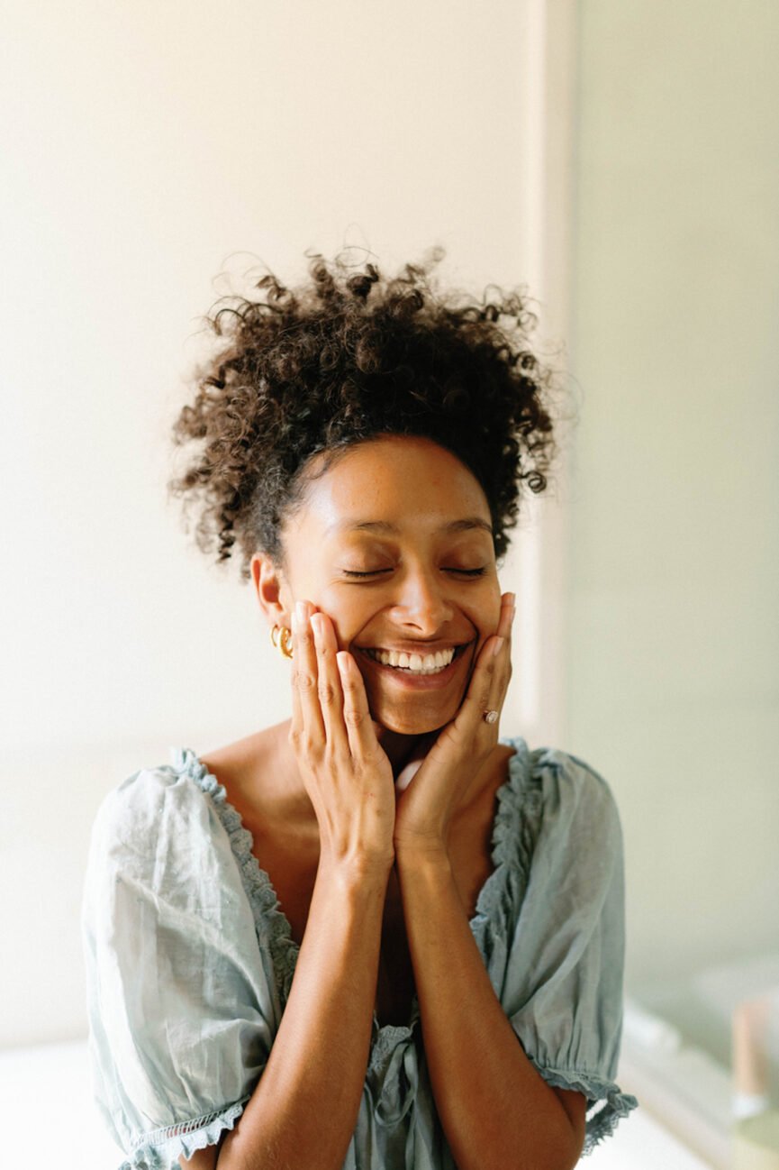 Mulher sorrindo no espelho.