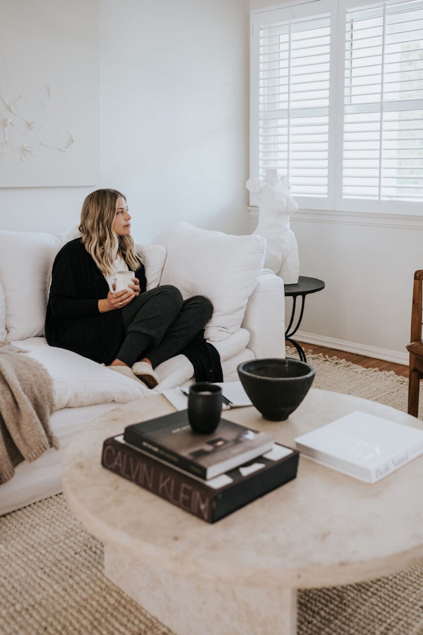 Woman journaling on couch.