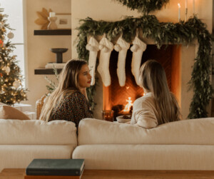 women talking by fireplace