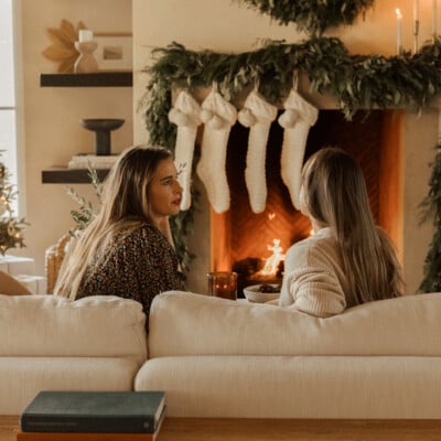 women talking by fireplace