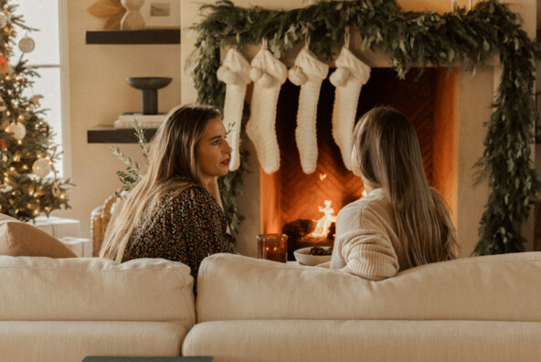 women talking by fireplace