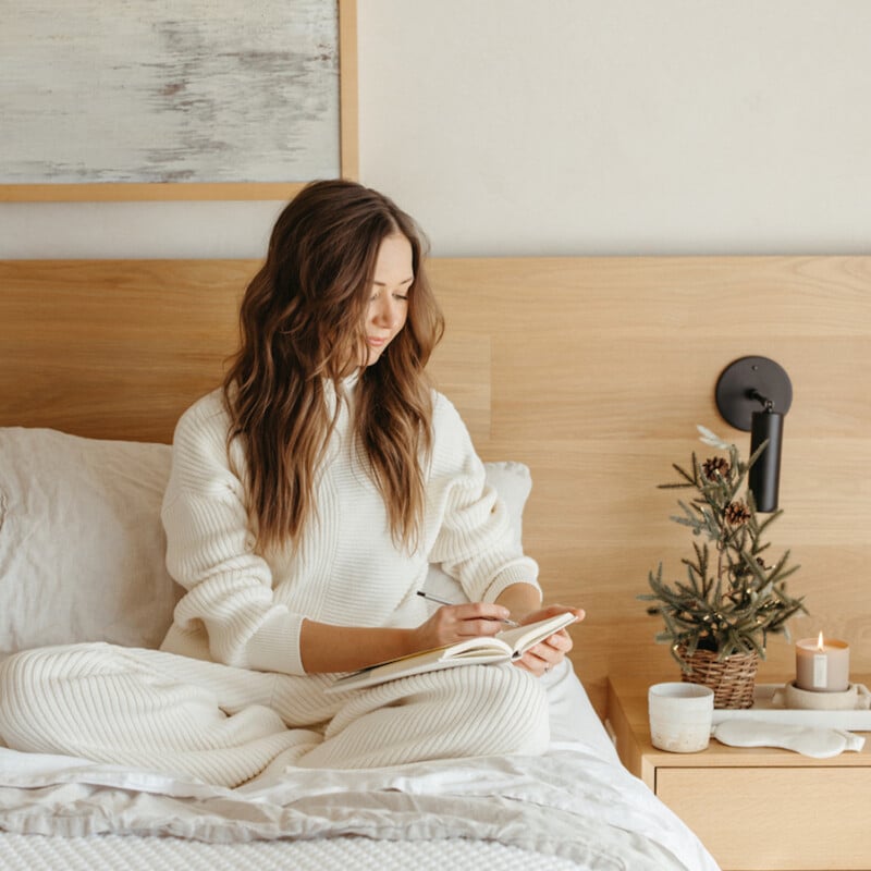 Camille Styles journaling in holiday sweater.