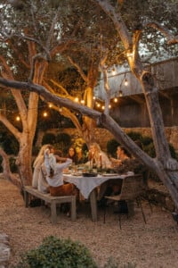 Friends at holiday dinner party around table at night
