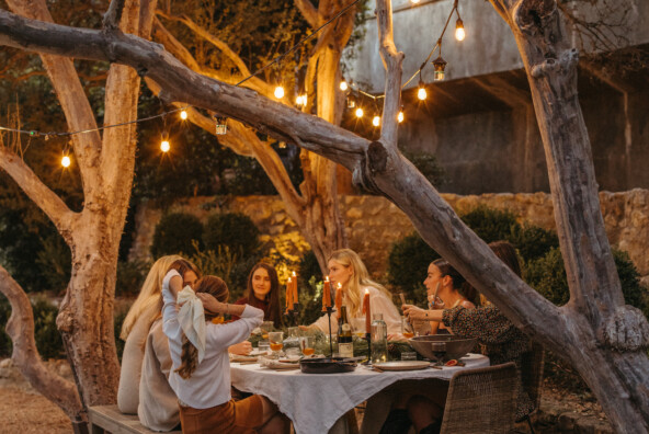 Friends at holiday dinner party around table at night