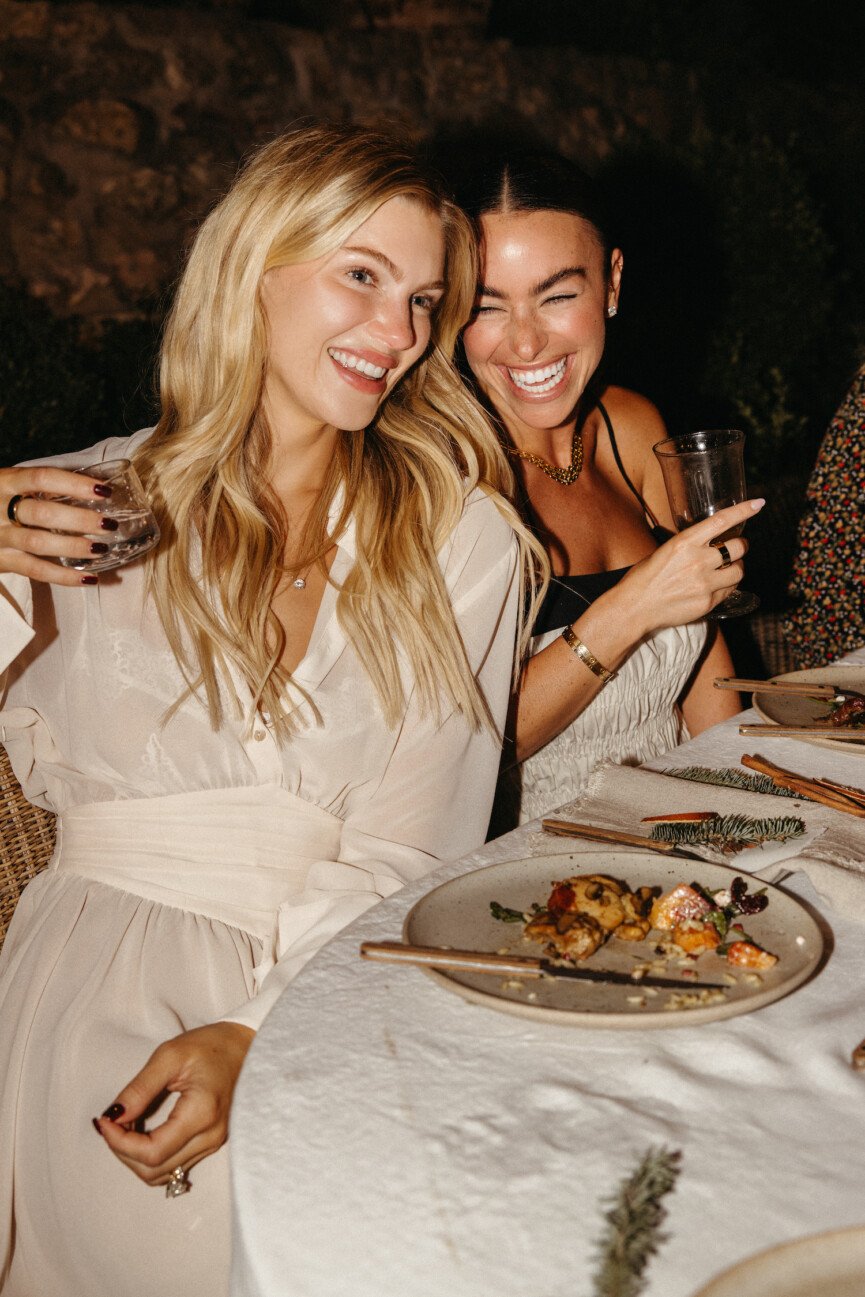 Friends at holiday backyard dinner party around table at night - Mari Llewellyn and Sami Spalter