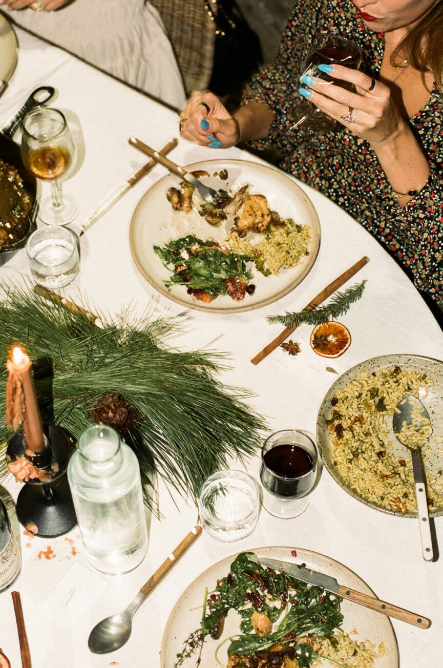 Friends at holiday backyard dinner party around table at night