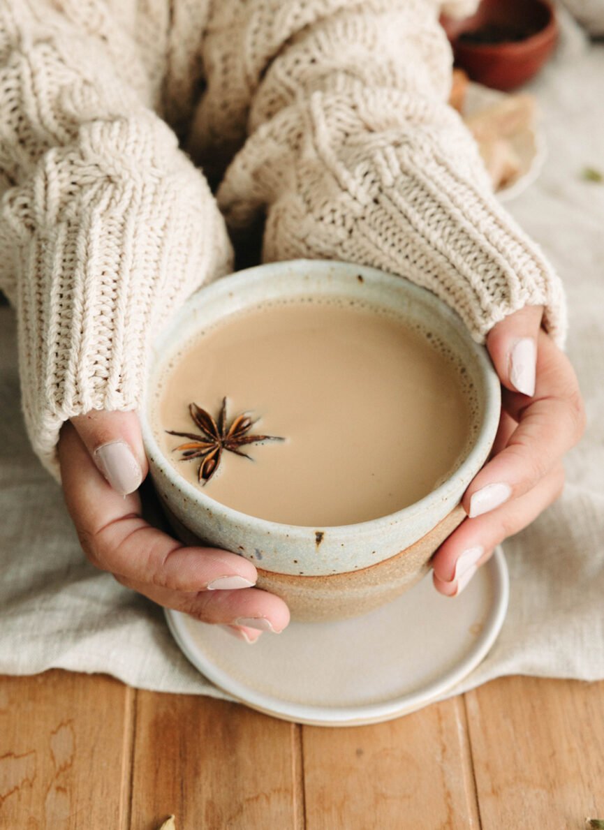 Woman holding cup of chai tea.