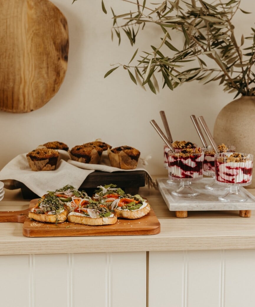 berry yogurt parfait, muffins, and toasts on serving trays