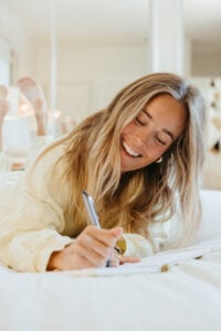 Woman joy journaling in bed