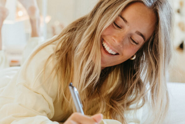 Woman joy journaling in bed