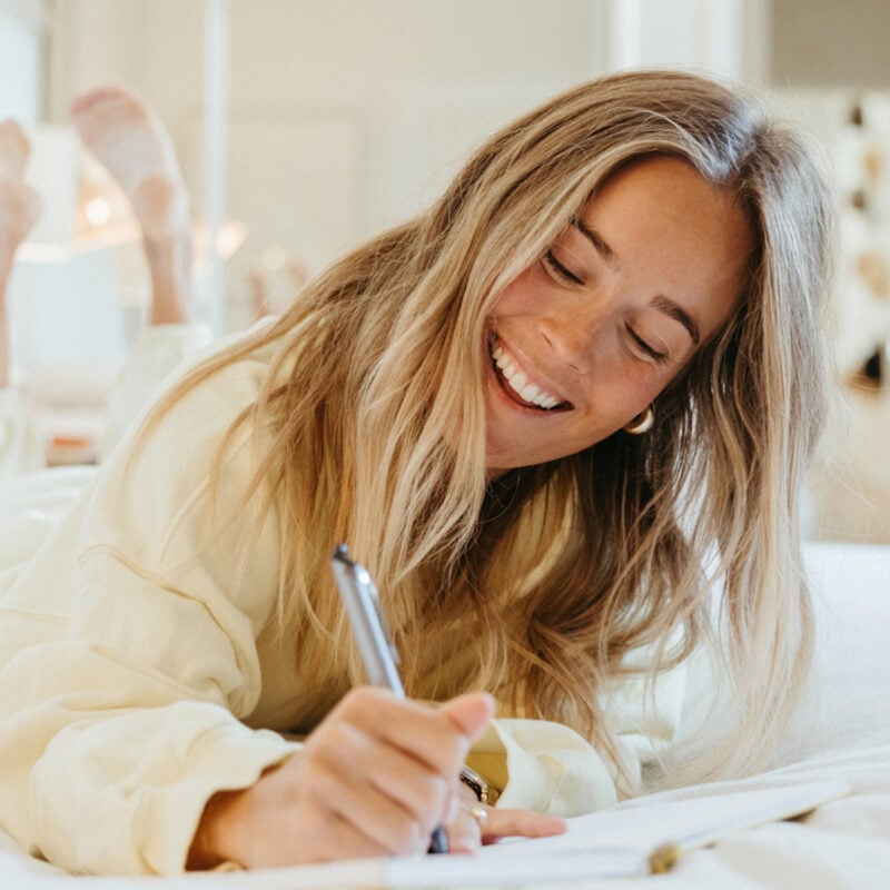 Woman joy journaling in bed