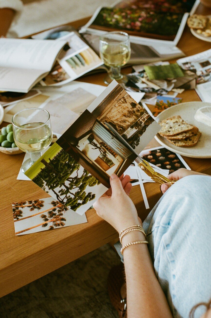 Friends gathered around a table creating vision boards during an intimate vision board party