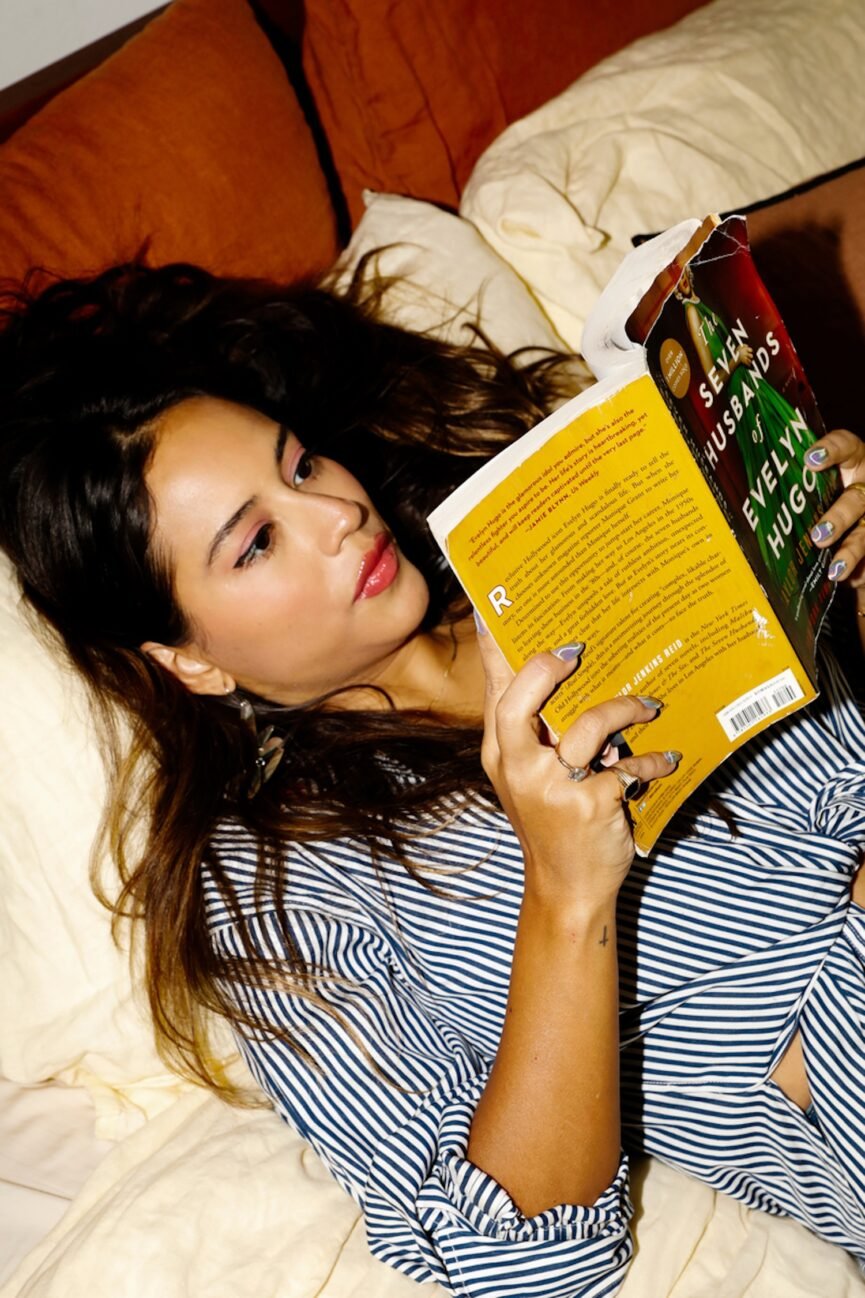 Woman reading book in bed.
