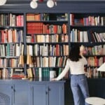Woman taking book off a shelf.