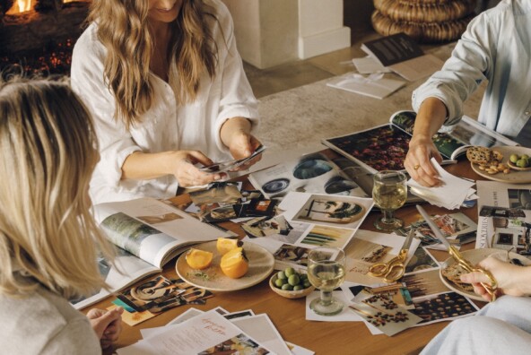 Close friends cutting out images and creating their vision boards together