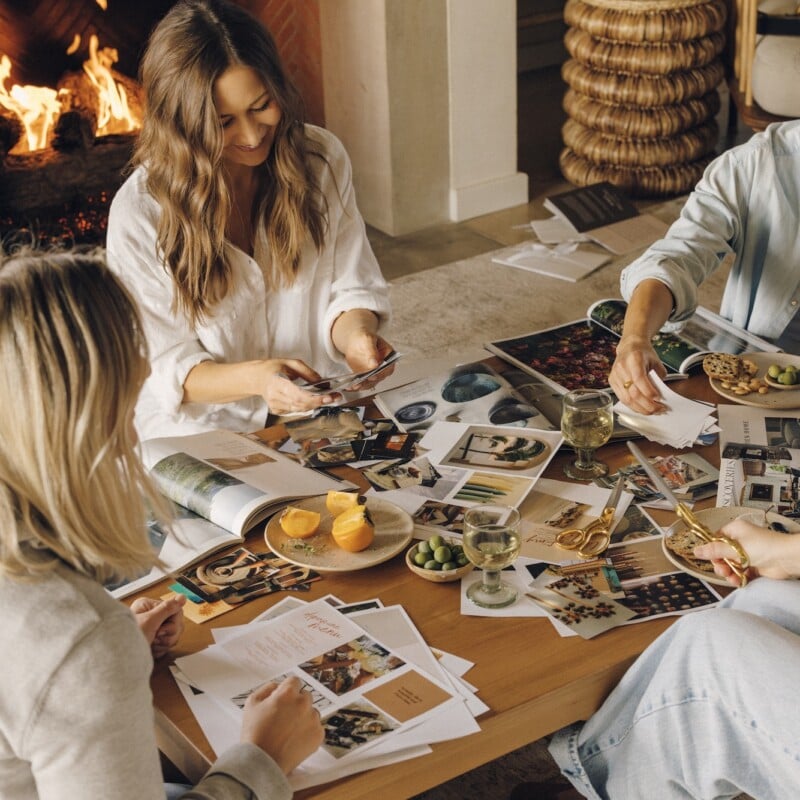 Close friends cutting out images and creating their vision boards together