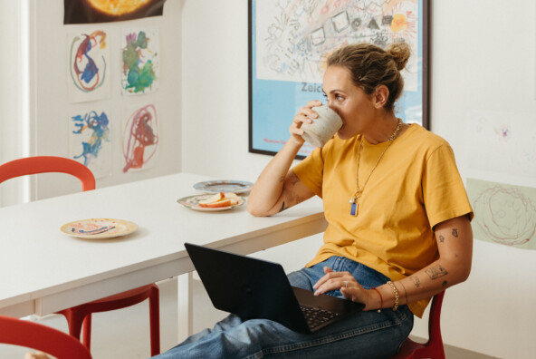 woman doing digital declutter sipping coffee in colorful kitchen