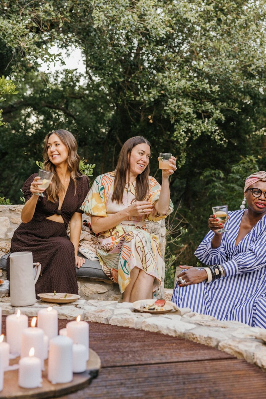 Vriendelijke vrouwen die buiten wijn drinken.
