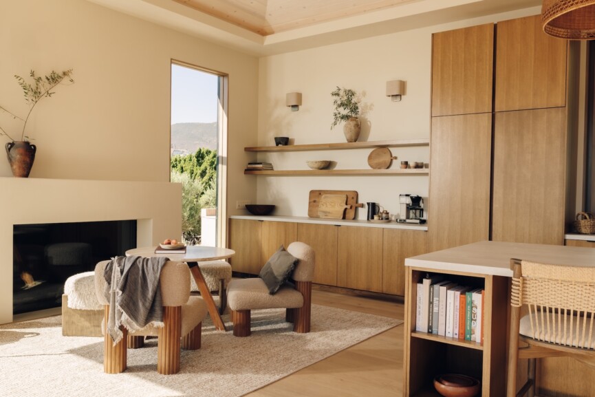 Sunlit great room at Casa Zuma with a plaster fireplace, oak cabinetry, open shelving and a cozy seating area.