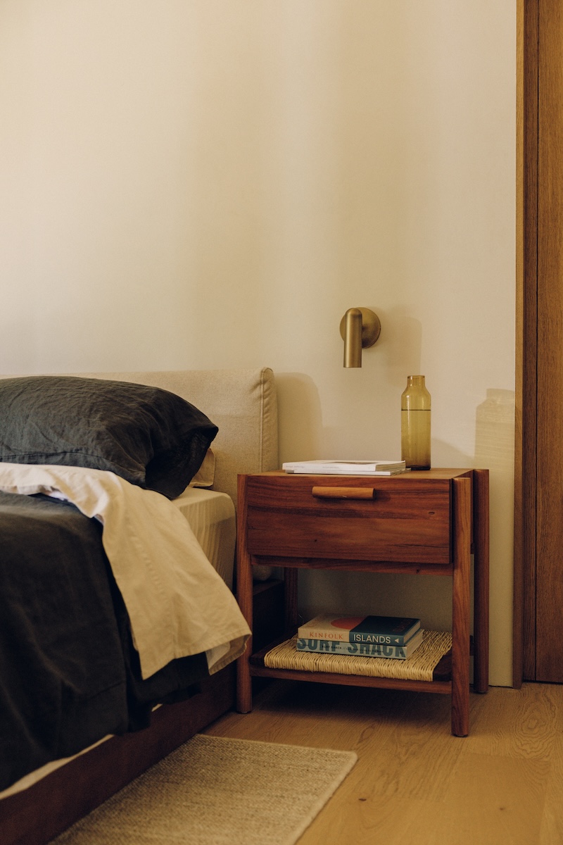 Wood nightstand styled beside the dark linen bed in Camille Styles’ son’s bedroom.
