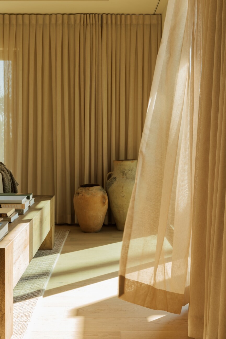 Floor-to-ceiling curtains filtering warm afternoon light in Camille Styles’ Malibu family room.