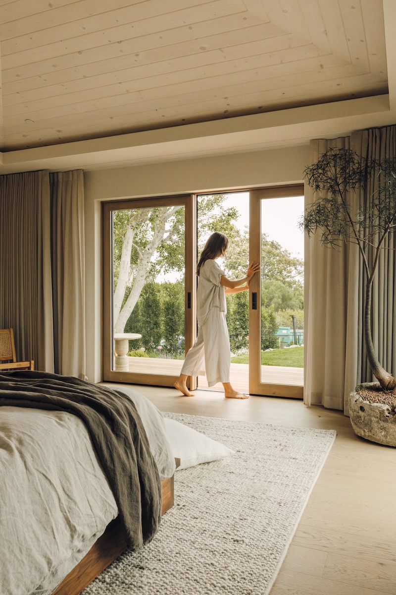 Camille Styles steps through the open doors of her Malibu bedroom onto the patio.