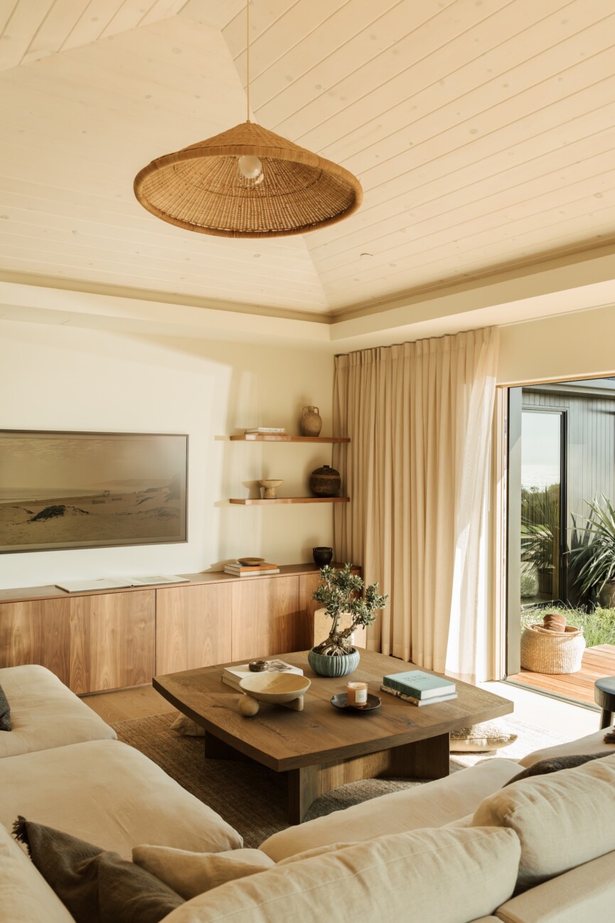 Sunlit family room with a neutral sectional, wood coffee table, and Casa Zuma woven pendant light.