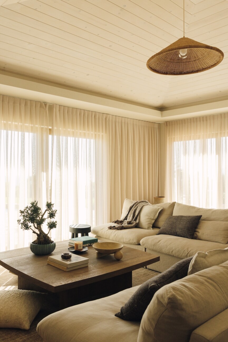 Sunlit Malibu family room with linen curtains, a neutral sectional, wood coffee table, and Casa Zuma pendant.